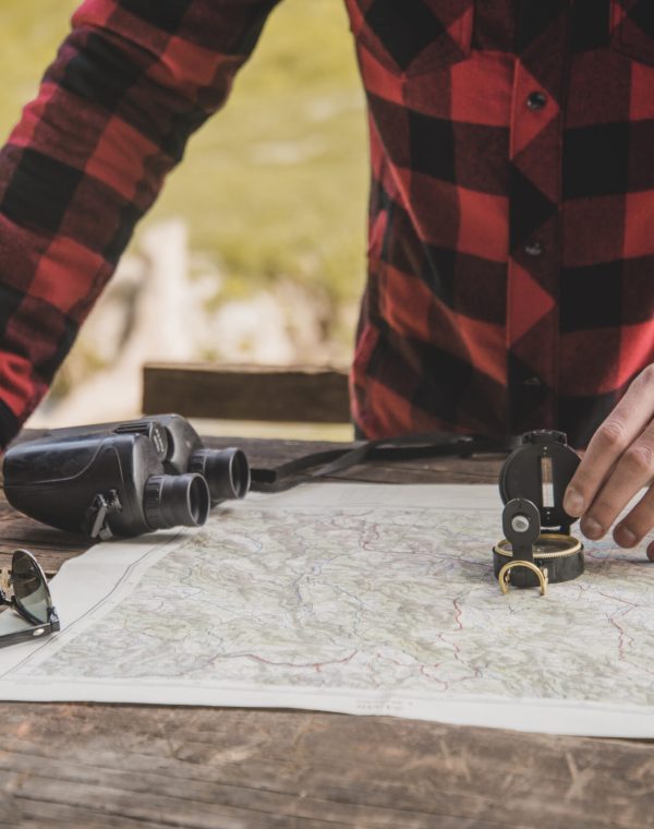 close-up-hand-with-compass-map